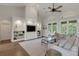 Bright living room featuring built-in shelving, hardwood floors, and a large window looking out to the lanai at 8102 Waterview Blvd, Lakewood Ranch, FL 34202