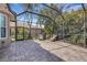 Large screened lanai featuring brick pavers and comfortable seating with lush greenery in the background at 8102 Waterview Blvd, Lakewood Ranch, FL 34202