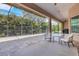 A large screened lanai with brick pavers, comfortable chairs, and view of the tropical landscape at 8102 Waterview Blvd, Lakewood Ranch, FL 34202
