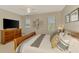Bright bedroom featuring a ceiling fan, large bed, and dresser with television at 8417 Karpeal Dr # 4, Sarasota, FL 34238