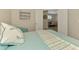 Bright bedroom featuring a nautical theme, with a decorative pillow and view to the dining area at 8417 Karpeal Dr # 4, Sarasota, FL 34238
