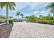 Paver entrance into a lush condo community, complete with palm trees, mature landscaping, and guest parking at 8417 Karpeal Dr # 4, Sarasota, FL 34238