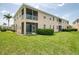 Well-maintained exterior view of the rear of a two story home with screened in patios and lush green lawn at 8417 Karpeal Dr # 4, Sarasota, FL 34238