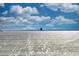 Expansive sandy beach with clear skies and a lifeguard tower in the distance, ideal for relaxation at 8417 Karpeal Dr # 4, Sarasota, FL 34238