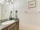 Half bath with vanity, granite countertop, and decorative accents at 8676 Ice Wine St, Sarasota, FL 34238
