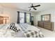 Bedroom with a ceiling fan, a queen bed, a mirror, and a dresser next to a window at 8676 Ice Wine St, Sarasota, FL 34238