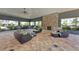 A clubhouse features comfortable outdoor seating, a dining table, and a stone fireplace at 8676 Ice Wine St, Sarasota, FL 34238