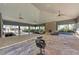 An indoor/outdoor clubhouse featuring a stone countertop bar, plenty of seating, ceiling fans, and a fireplace at 8676 Ice Wine St, Sarasota, FL 34238