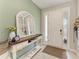 Bright foyer with a decorative mirror, console table, and a view of the entrance door at 8676 Ice Wine St, Sarasota, FL 34238