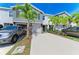 Charming townhome showcasing a well-kept lawn, vibrant landscaping, and a spacious driveway with cars at 8676 Ice Wine St, Sarasota, FL 34238