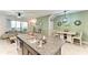 Kitchen island with sink and view of the dining and living areas at 8676 Ice Wine St, Sarasota, FL 34238