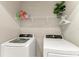 Neat laundry room featuring a modern washer, dryer, and shelf with detergents at 8676 Ice Wine St, Sarasota, FL 34238