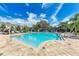 Bright community pool with beautiful water, brick trim, lounge chairs, and lush landscaping at 8676 Ice Wine St, Sarasota, FL 34238