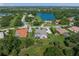 Aerial view of home with a lake view, highlighting the screened-in lanai and lush landscaping at 8924 Misty Creek Dr, Sarasota, FL 34241