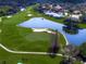 Stunning aerial view of a golf course with a pond and beautiful homes in the background at 8924 Misty Creek Dr, Sarasota, FL 34241