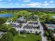 Bird's-eye view of the golf course clubhouse, parking lot, and tennis courts in a lush setting at 8924 Misty Creek Dr, Sarasota, FL 34241