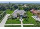 Aerial view of home with lush landscaping, tile roof and circular driveway at 8924 Misty Creek Dr, Sarasota, FL 34241