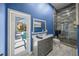 Modern bathroom boasts blue walls, gray vanity with gold hardware, and a glass-enclosed shower at 8924 Misty Creek Dr, Sarasota, FL 34241