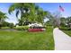 Entrance to Misty Creek featuring lush landscaping, a community sign, and an American flag at 8924 Misty Creek Dr, Sarasota, FL 34241