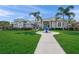 Charming home with lush green lawn, a decorative water feature, and a welcoming entrance at 8924 Misty Creek Dr, Sarasota, FL 34241