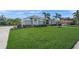 Expansive front yard of home, featuring manicured lawn and mature palm trees at 8924 Misty Creek Dr, Sarasota, FL 34241
