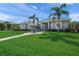 Beautiful home featuring lush landscaping, palm trees, and a circular walkway at 8924 Misty Creek Dr, Sarasota, FL 34241