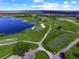 Scenic aerial view of a golf course with a blue lake, sand traps, and lush green fairways at 8924 Misty Creek Dr, Sarasota, FL 34241