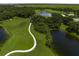 Aerial view of a scenic golf course with winding cart paths, serene lakes, and lush green fairways at 8924 Misty Creek Dr, Sarasota, FL 34241
