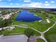 Expansive aerial shot of a verdant golf course featuring serene lakes and lush green fairways under a blue sky at 8924 Misty Creek Dr, Sarasota, FL 34241
