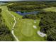 Scenic aerial view of a golf course with winding cart paths, a serene lake, and vibrant green fairways at 8924 Misty Creek Dr, Sarasota, FL 34241