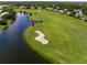 Picturesque aerial view of a golf course alongside a tranquil lake and manicured green fairways at 8924 Misty Creek Dr, Sarasota, FL 34241