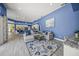 Open-concept living space featuring a large sectional sofa, blue accent wall, and an adjacent kitchen area at 8924 Misty Creek Dr, Sarasota, FL 34241