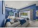 Bright living area with comfortable seating, blue accent wall, and sliding glass doors to a private pool area at 8924 Misty Creek Dr, Sarasota, FL 34241
