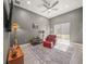 A comfortable living room featuring a plush red chair, ceiling fan and sliding glass doors to the backyard at 8924 Misty Creek Dr, Sarasota, FL 34241
