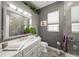 Bathroom featuring a gray vanity with marble top, walk-in shower with glass door and modern accents at 8924 Misty Creek Dr, Sarasota, FL 34241