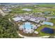 Community aerial view showcasing clubhouse with pools, tennis courts, and recreational areas amidst lush landscaping at 9012 Tequila Sunrise Dr, Sarasota, FL 34241