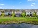 Aerial view of neighborhood with well-maintained lawns and a community pond at 9012 Tequila Sunrise Dr, Sarasota, FL 34241