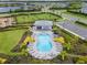 Community pool with lounge chairs, lush landscaping, and a covered pavilion, ideal for relaxation and socializing at 9012 Tequila Sunrise Dr, Sarasota, FL 34241