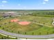 Aerial view of baseball and soccer fields with manicured green grass and trees at 9012 Tequila Sunrise Dr, Sarasota, FL 34241