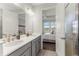 Bathroom featuring double sinks, elegant light fixtures, and a view into the well-lit primary bedroom at 9012 Tequila Sunrise Dr, Sarasota, FL 34241