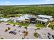 Aerial view showcasing the community center with a pool, buildings, and surrounding greenery at 9012 Tequila Sunrise Dr, Sarasota, FL 34241