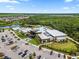 Community center with a pool, buildings, parking, and lush green landscaping at 9012 Tequila Sunrise Dr, Sarasota, FL 34241