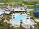 Aerial view of community pool area, with palm trees, lounge chairs, and sunbathing areas at 9012 Tequila Sunrise Dr, Sarasota, FL 34241