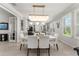 Elegant dining room with a modern chandelier, large windows, and beautiful flooring at 9012 Tequila Sunrise Dr, Sarasota, FL 34241