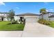 Charming one-story home with a well-manicured lawn, palm tree, neutral paint, and attached two car garage at 9012 Tequila Sunrise Dr, Sarasota, FL 34241