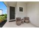 Welcoming front porch with seating, neutral paint, and a black front door at 9012 Tequila Sunrise Dr, Sarasota, FL 34241