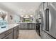 Open-concept kitchen with stainless steel appliances, island, and stylish pendant lighting overlooking the home's living area at 9012 Tequila Sunrise Dr, Sarasota, FL 34241