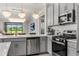 Stylish kitchen with stainless steel appliances, gray cabinets, and pendant lighting at 9012 Tequila Sunrise Dr, Sarasota, FL 34241