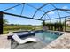 Stunning screened-in pool with a spa, a water feature, and a view of a peaceful pond at 9012 Tequila Sunrise Dr, Sarasota, FL 34241