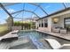 Screened-in pool area with a waterfall feature, lounge seating, and outdoor TV for relaxation and entertainment at 9012 Tequila Sunrise Dr, Sarasota, FL 34241